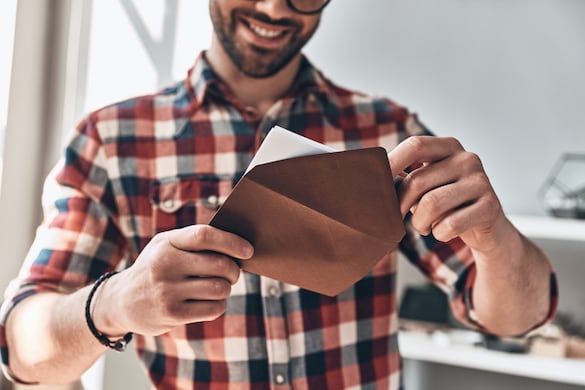 Happy man smiling while he opens a greeting card