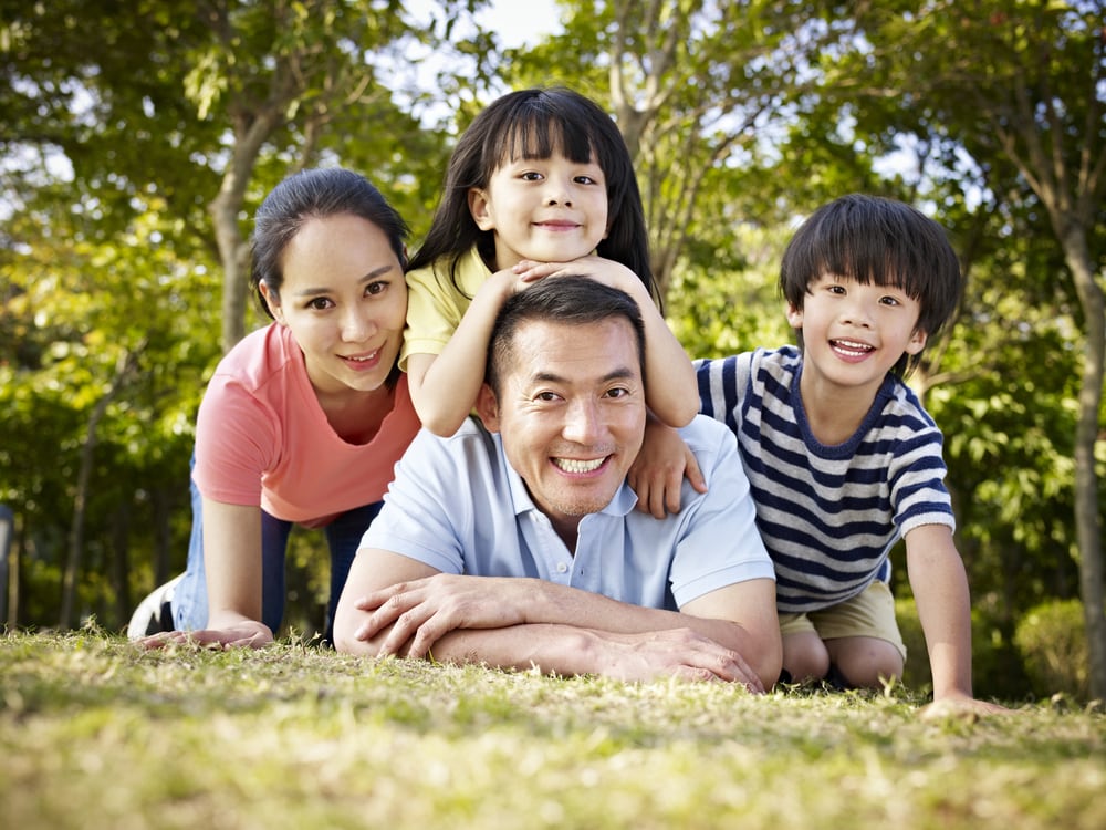 Happy family posing for photo outdoors on the grass